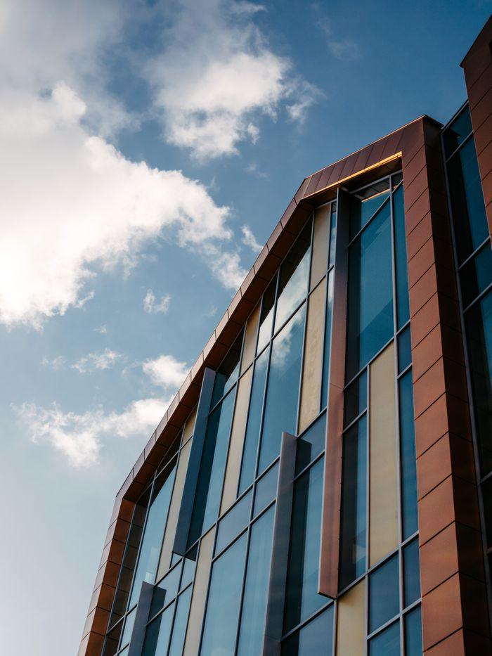 Stylish architecture with glass and metal reflecting the blue sky.